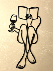 Minimalist Female Metal Silhouette Holding Wine and a Book