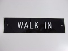WALK IN SIGN/PLAQUE WALL OR DOOR MOUNTED BLACK PLASTIC 8″ X 2″
