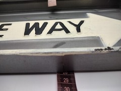 One way metal sign 16 inch long and 1 inch deep with hangers on back.